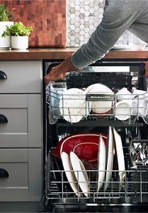 On the left, an open dishwasher viewed from above — packed with the aftermath of good cooking and a great meal.